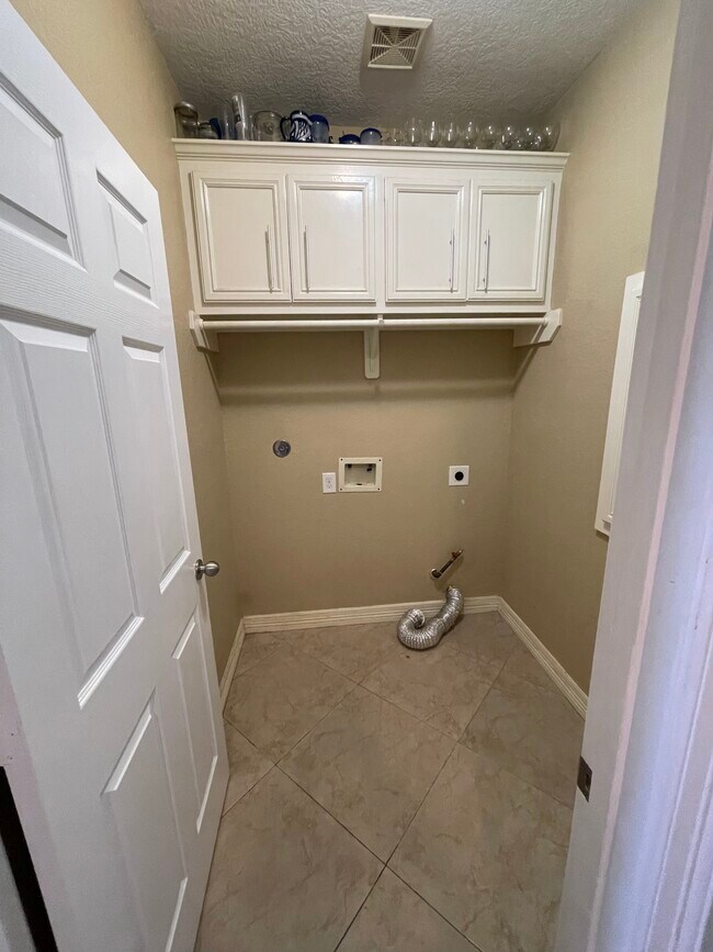 Laundry room with custom wood cabinets gas dryer connection - 600 River Bend Dr