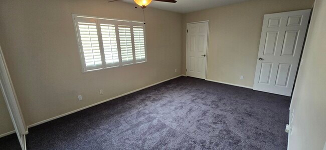 Master bedroom features two closets and ceiling fan - 14365 Foothill Blvd