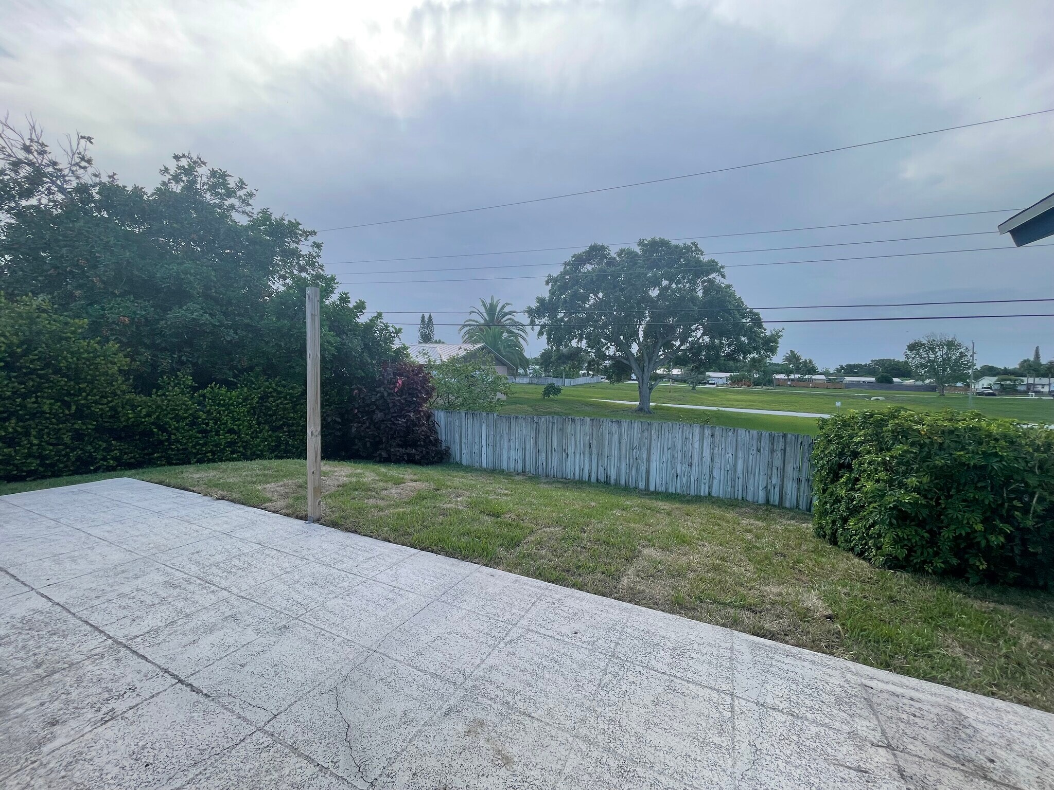 Private fenced backyard with concrete patio no houses behind it - 7399 SE Flamingo Way