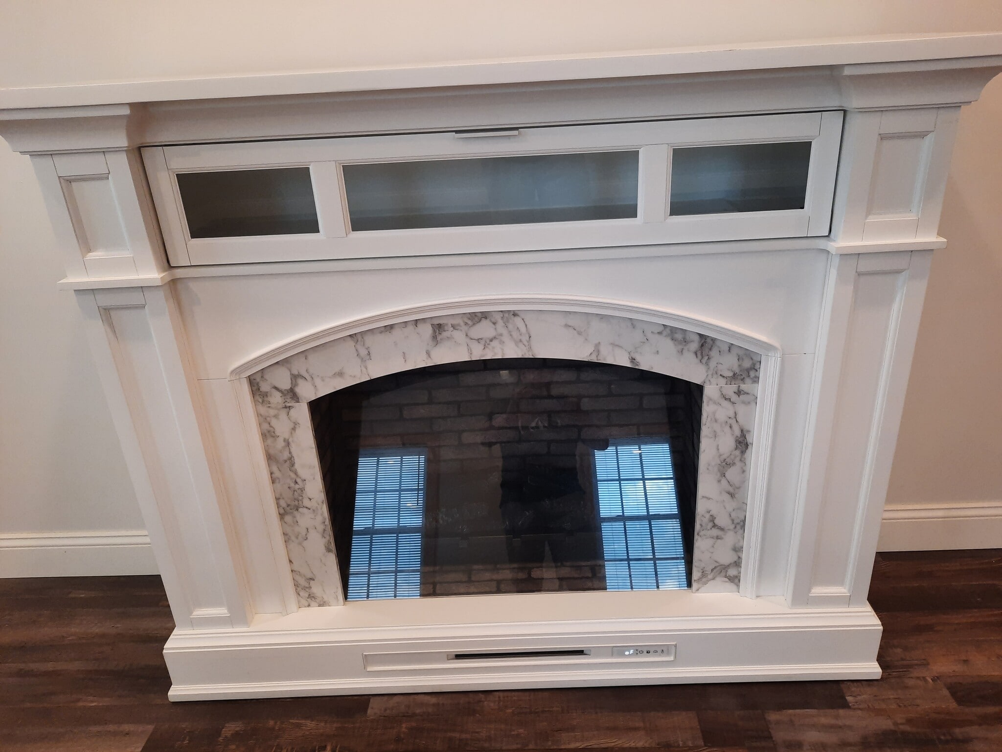 marble living room fireplace with tilt down cupboard with 5 flames and remote control heater - 247 Main St