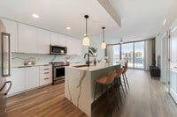 Tower Building - Renovated II kitchen with stainless steel appliances, white quartz countertops, white cabinetry, and hard surface flooring - Avalon West Palm Beach