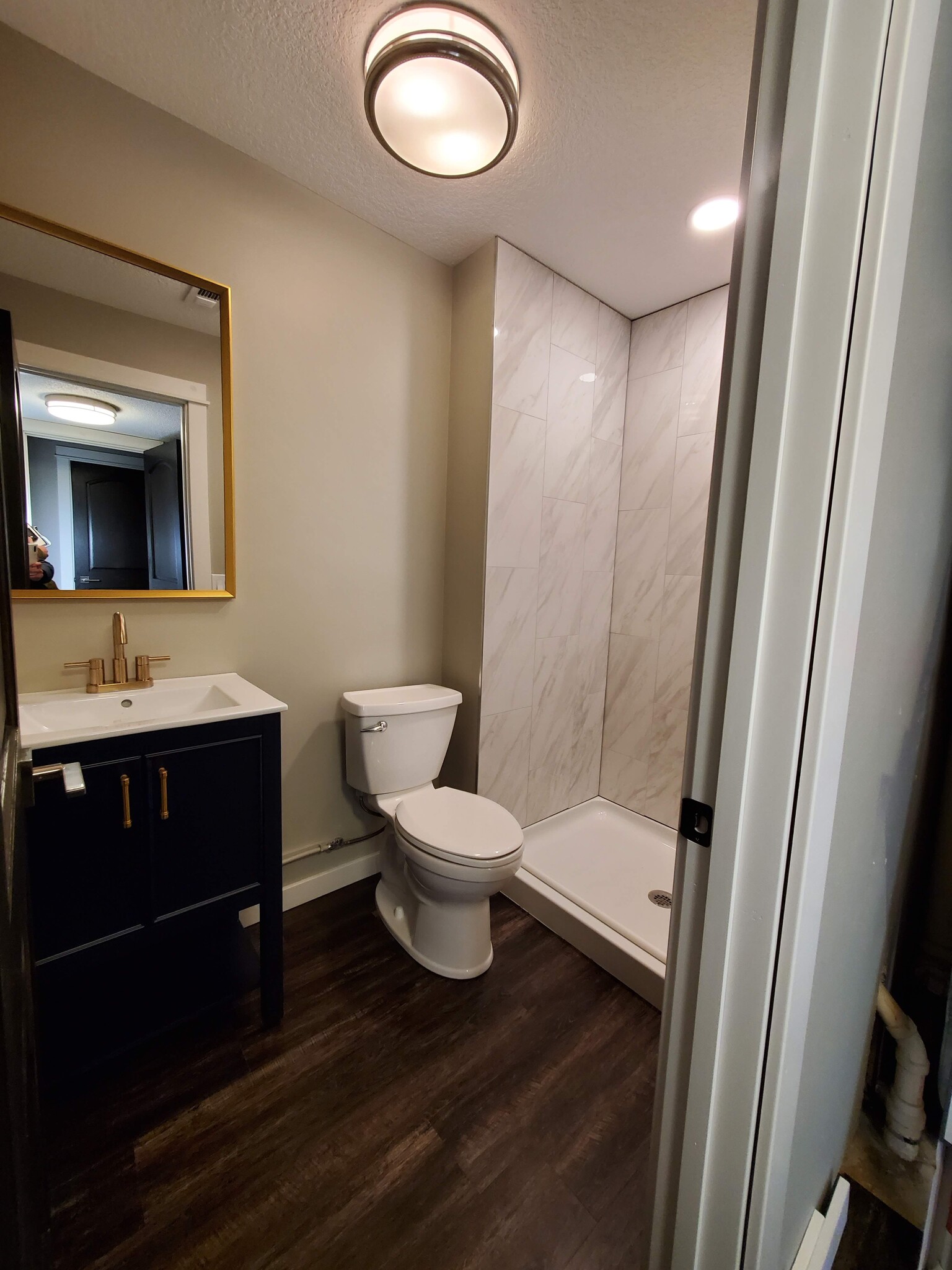 Lower level bathroom has new tiled shower surround, floor, vanity, faucet, and lighting. - 2525 Cedar Hills Drive