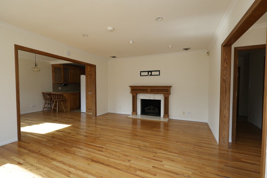 Bright open concept living space with oak wood floors and a working fire place. - 4831 Canoga Ave