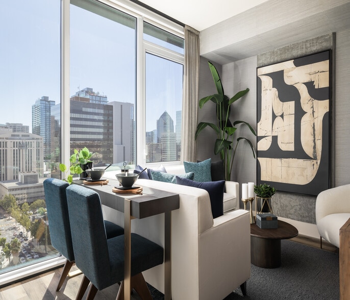 Modern apartment interior with elegant dining area, plush seating, and panoramic city views through large windows. - Ancora Apartments