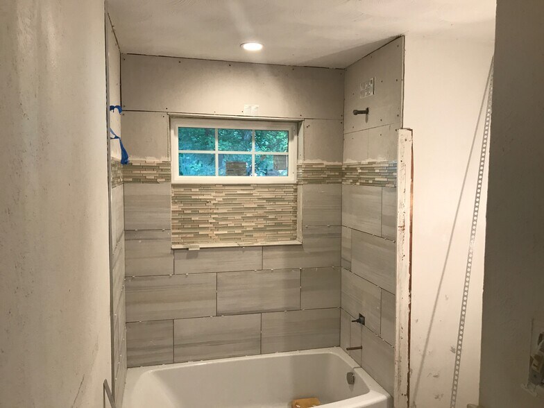 In progress of the bathroom remodel. I am loving the new tile work! All new everything; toilet, tub, tile work, window, sink, cabinet. - 6520 Finch