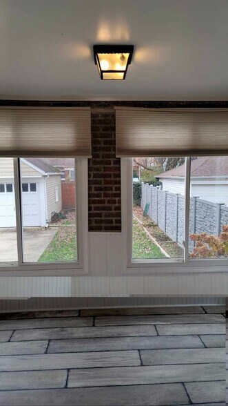 Bright bonus sunroom with large windows on multiple sides, offering abundant natural light and a per - 90 E 216th St