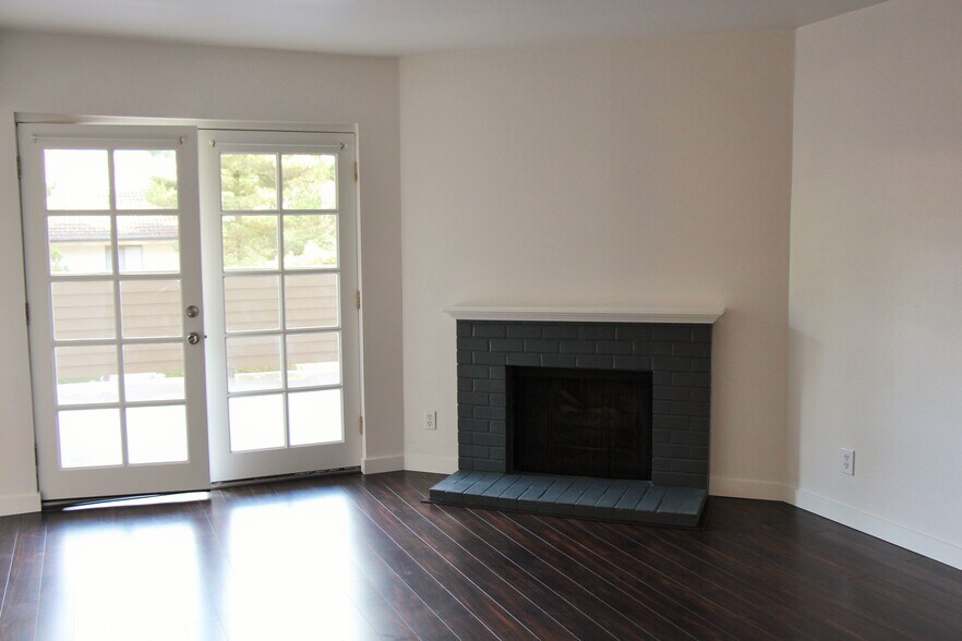Living room includes a fireplace and french doors opening to a large deck. - 10418 Northeast 32nd Place