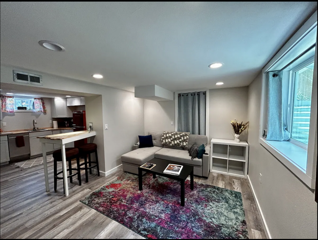 Open concept living room, dining room (bar top), and kitchenette area. - 4115 SE Gladstone St