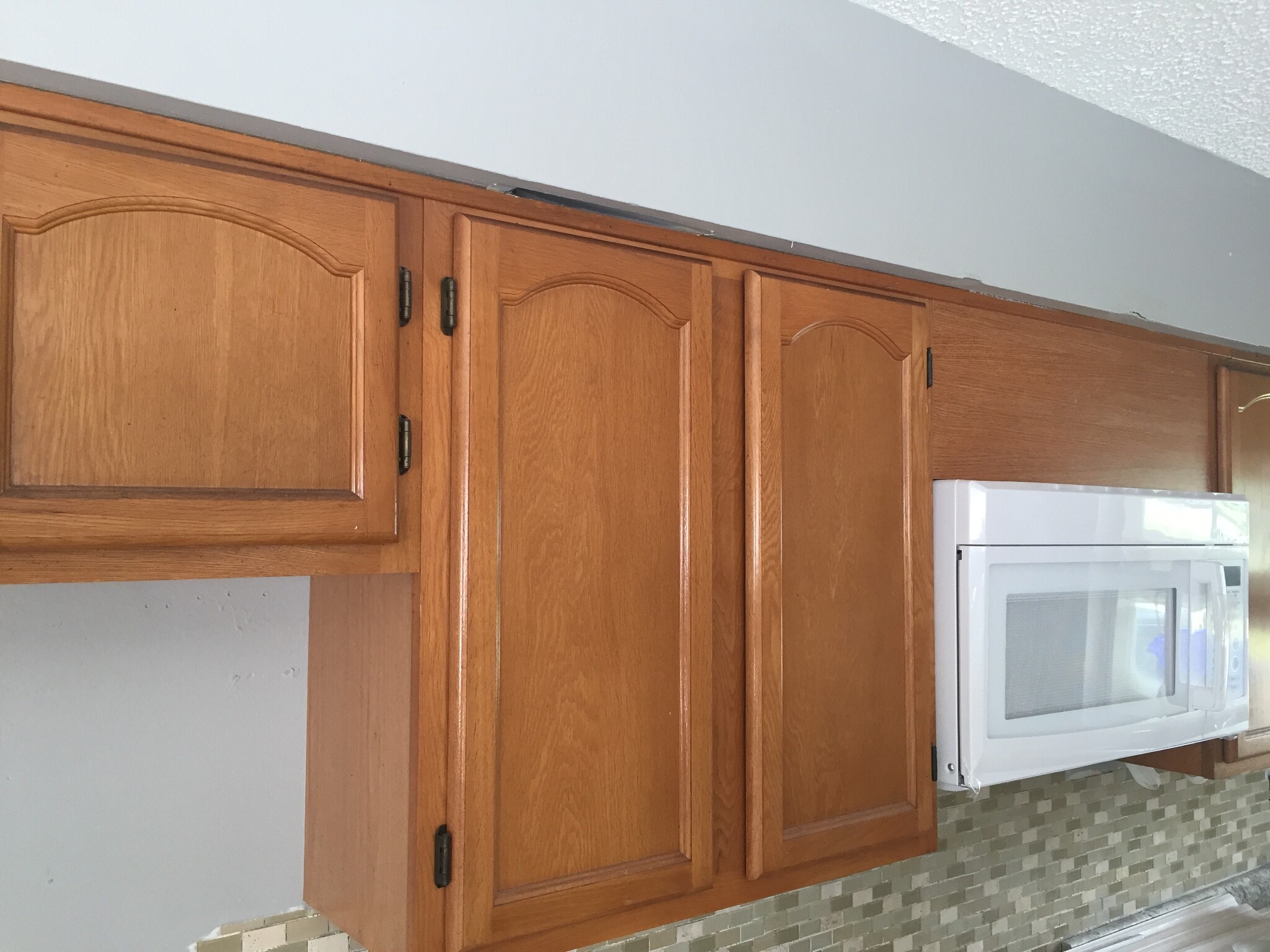 Solid wood cabinets, above the range microwave, and backsplash - 1219 W Highland St