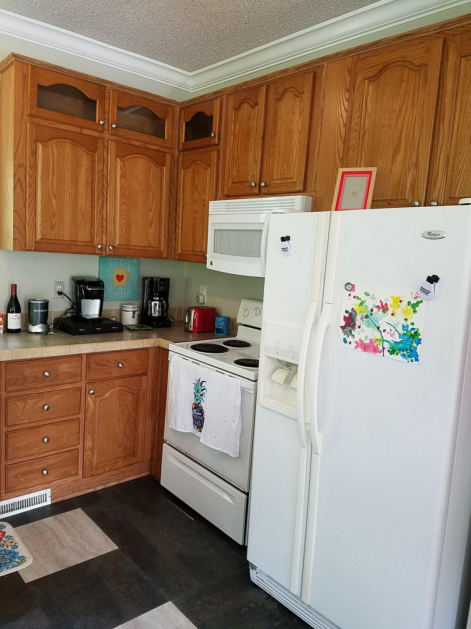 Kitchen with solid surface counters, stove, microwave and refrigerator. - 221 Long St