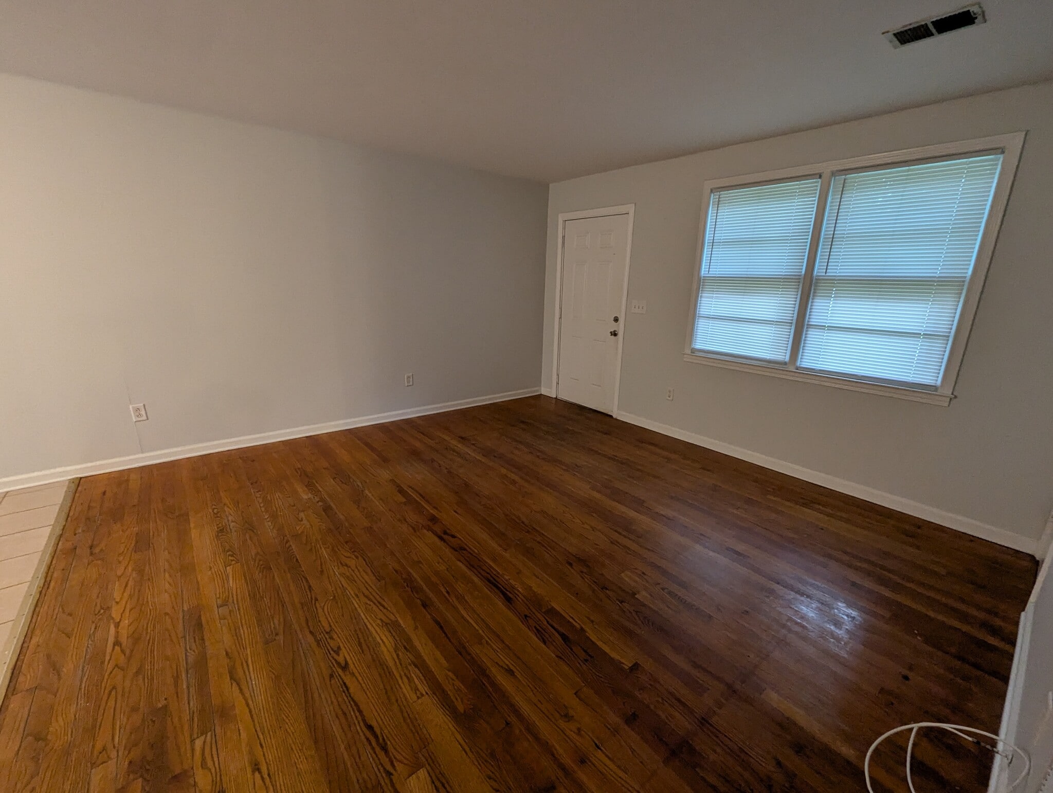 Front living room entryway with hardwood flooring and wide dual windows. - 1527 Brookbank Ave
