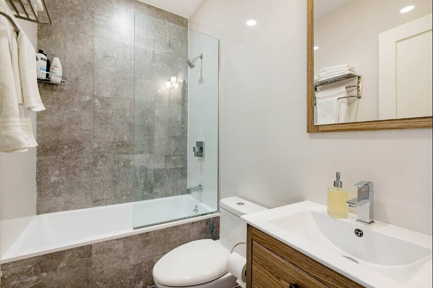 Secondary bath features a deep soaking tub and modern elegant finishes - 504 Maple St