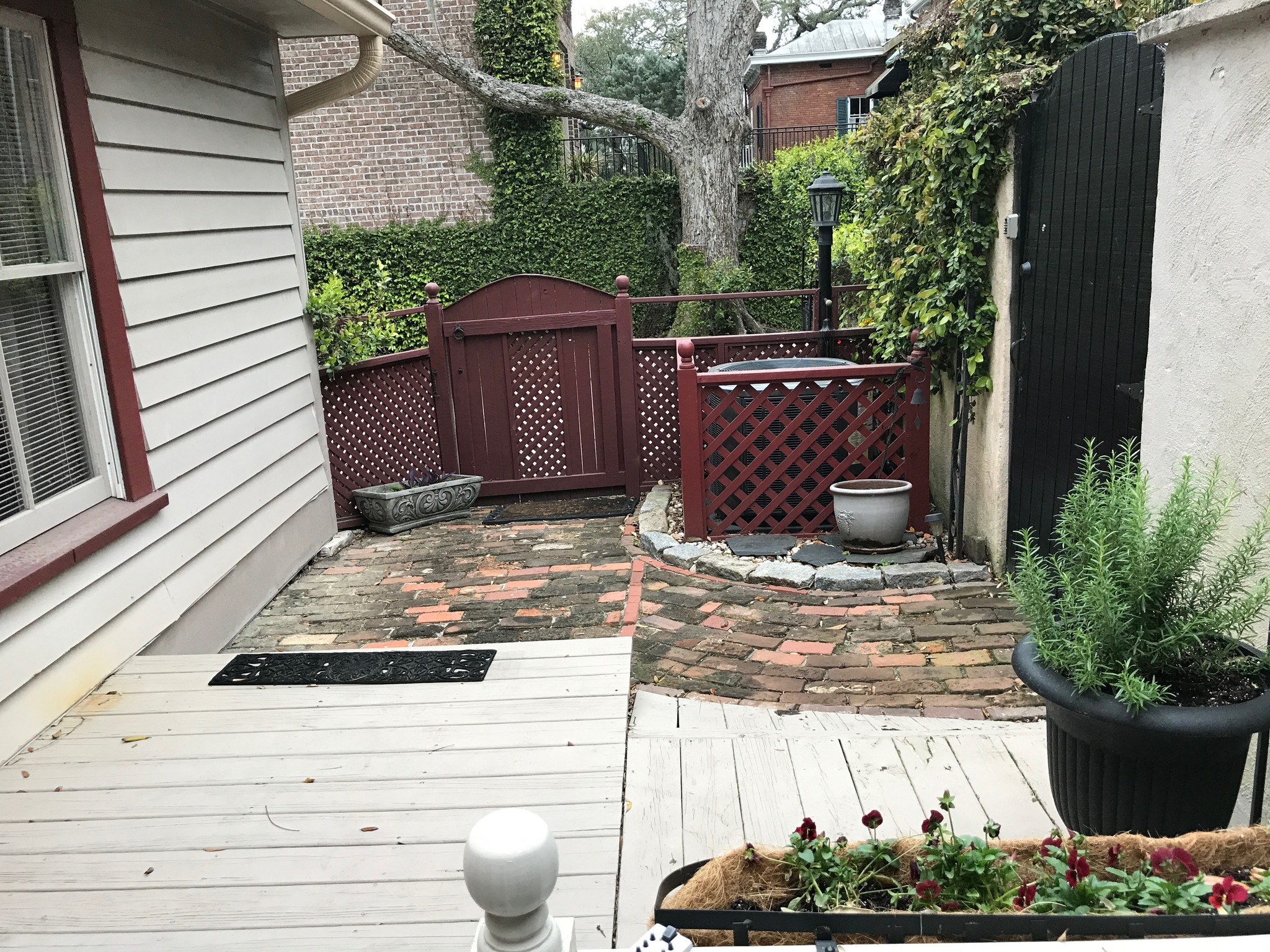 Gated courtyard w/deck and bricked walkway leading to adjacent driveway - 541 E Jones Ln