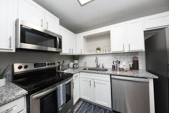 Kitchen with granite counters, modern cabinetry, and stainless appliances - The Edwin