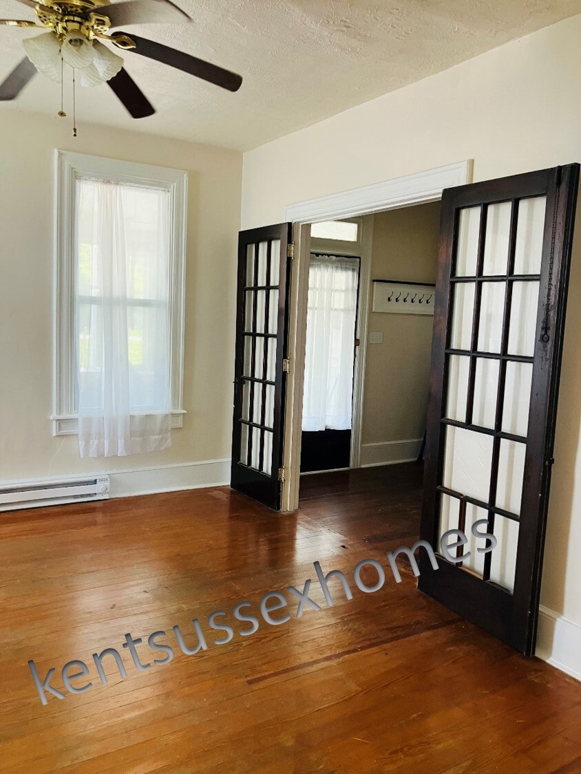 High ceilings and original French doors and hardwood floors in living room - 112 Mechanic Street