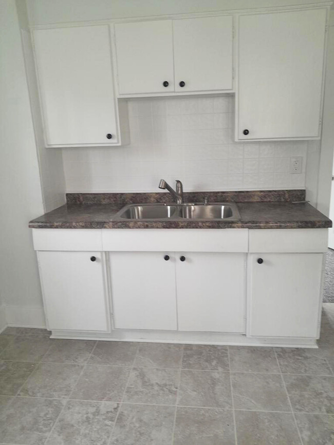 New tile floor with new refrigerator and range - 308 McDonough St