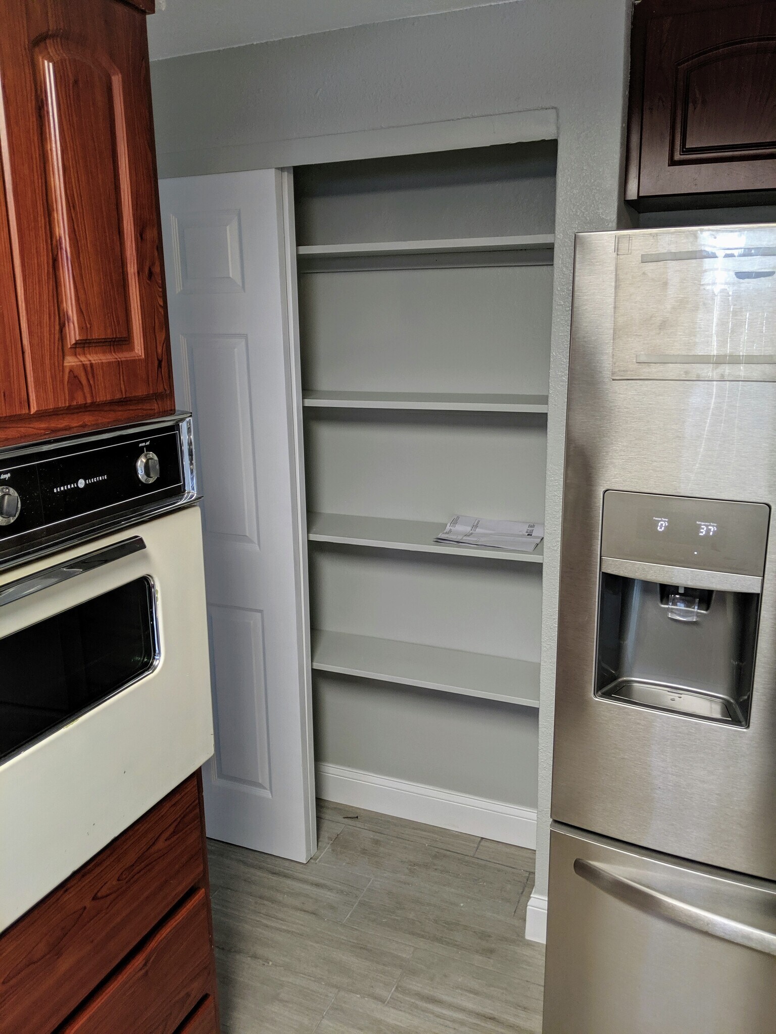 Built-in pantry shelving next to fridge with water and ice dispenser - 1147 Jennings Dr