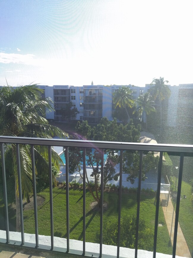 Large back patio overlooks treelined pool area and community greenspace. - 198 NW 67th St