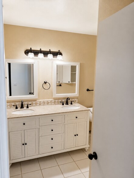Spacious bathroom vanity area with dual sinks, cabinet storage, and updated fixtures. - 339 E Taft Ave