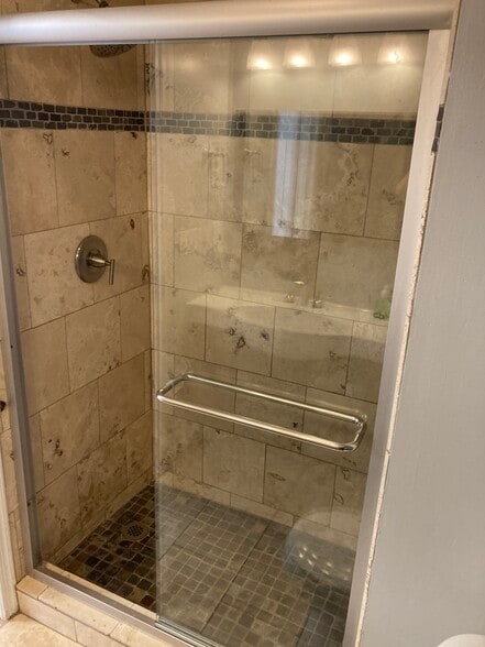 Master bath has floor to ceiling travertine shower with built in seat and rainfall shower head - 1419 Founders Way