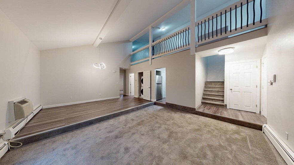 Modern living room with laundry in unit and stunning loft access - Lofts & Townhomes @ International Apartments