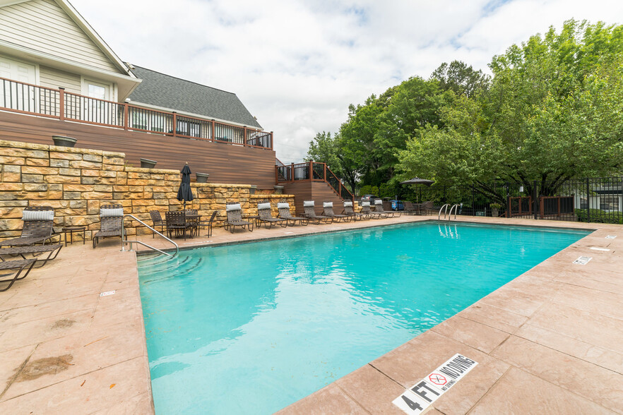 Sparkling pool with poolside lounge furniture and umbrellas - Decatur Flats