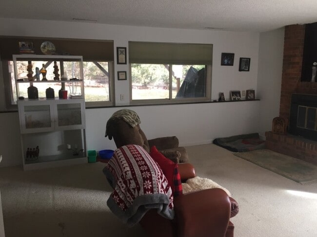 Living room with view to back yard - Gilcrest Apartments - Utilities Included