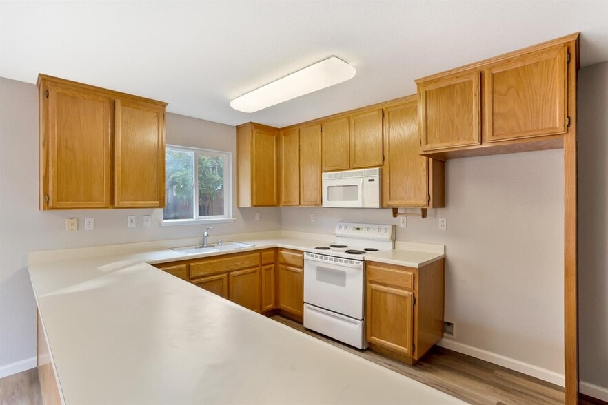 The view into the kitchen, stove, microwave, & space for fridge. - 3038 Courtside Dr