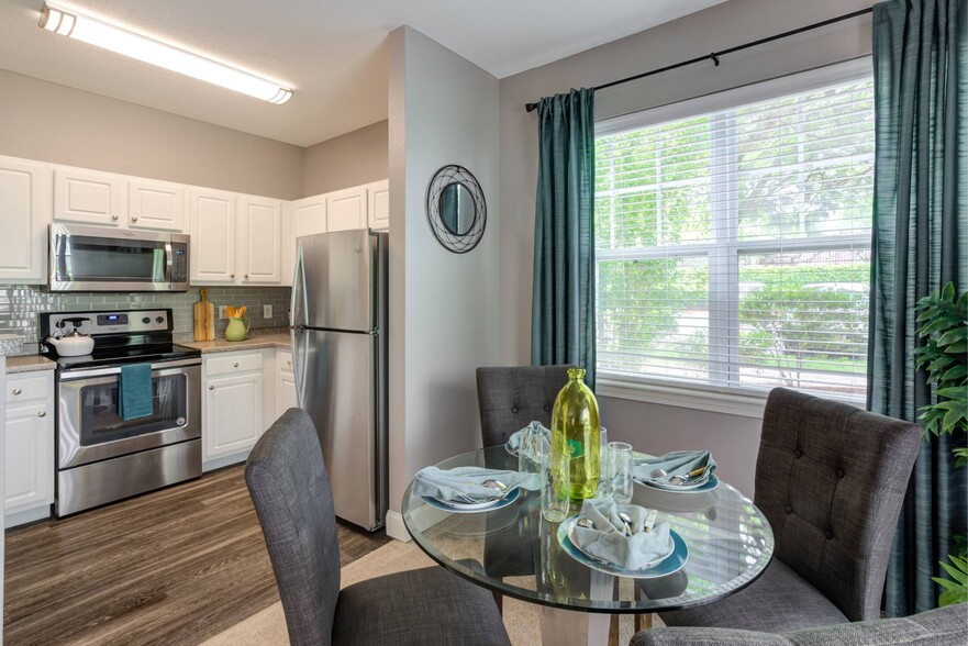 White cabinets with stainless steel microwave, stove and refrigerator. - Hawthorne Commons