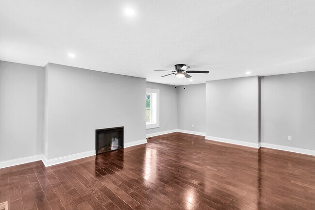 The oversized living room offers a gas fireplace, Oak Mocha hardwood floors, and fresh paint - 2416 Magee Road Ext