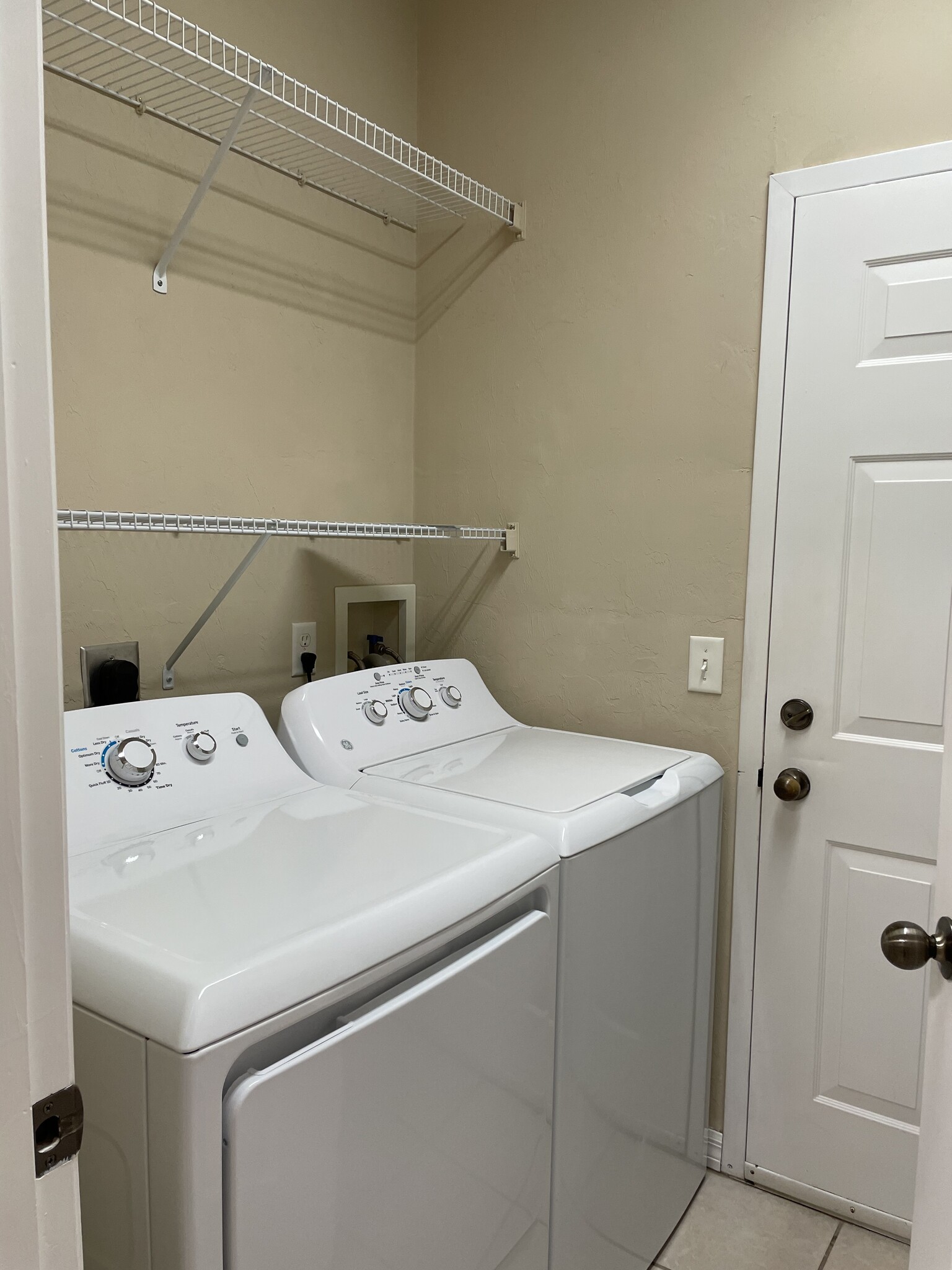 Laundry with washer and dryer and shelving. - 13200 W Newberry Rd