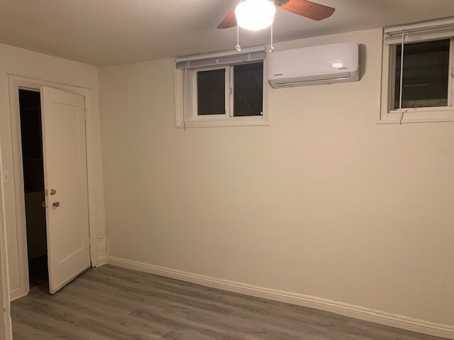 View of the second bedroom with a ceiling fan, a heat/air minisplit system, & door to bathroom. - 24606 University Ave