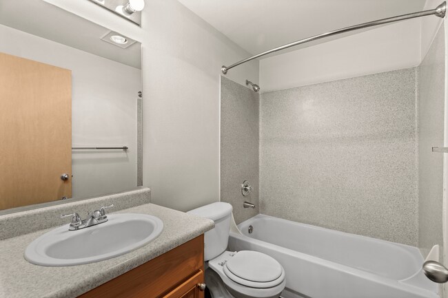 Full bathroom with a tub, shower, and generous vanity. - Villas at Lawrence