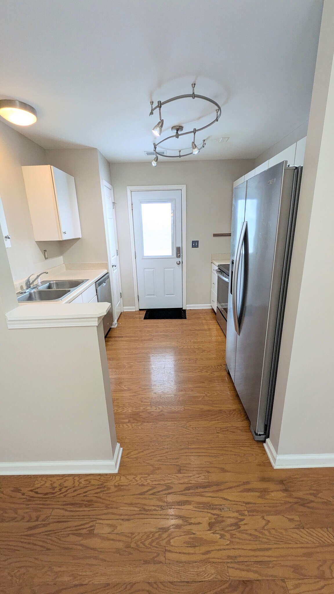 Kitchen with stainless steel appliance and exit to parking area - 3381 Weston St