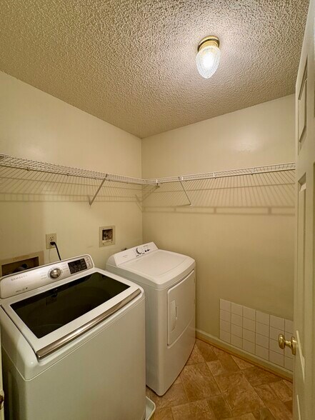 Laundry room with generous hanging space and storage racks - 208 Quarter Trl