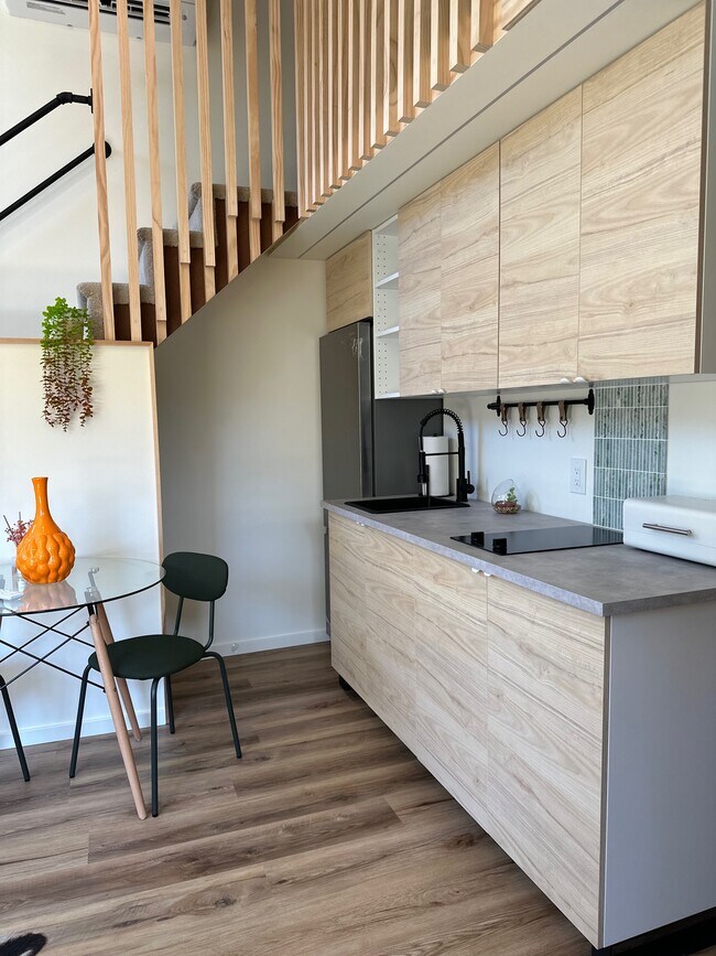 Kitchen with microwave and pantry under stairs - 7044 McLaren Ave