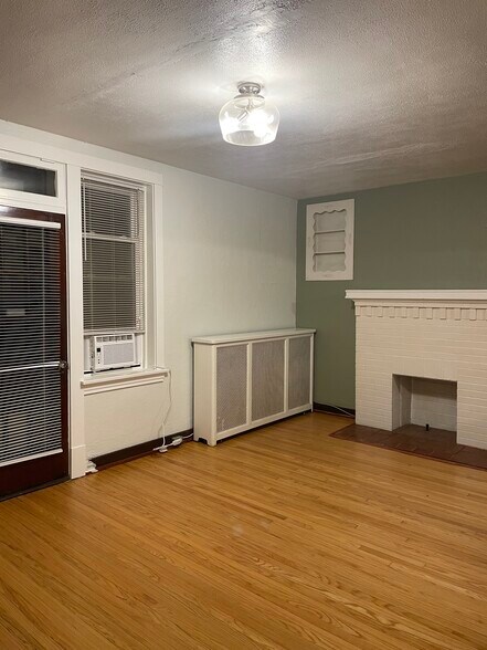 Living Room with Decorative Fireplace. (during renovation, trim is all white now) - 4417 Rosa Ave