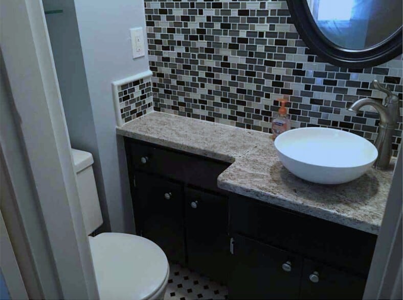 Fully updated half bath with granite counter top, vessel sink, and glass mosaic tile. - 2325 Broadmeade Road
