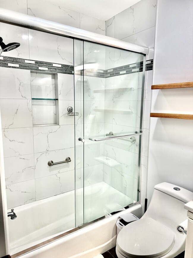 Beautiful marble tile bathroom walls, high quality glass sliding doors and skylight - 3163 Helms Ave