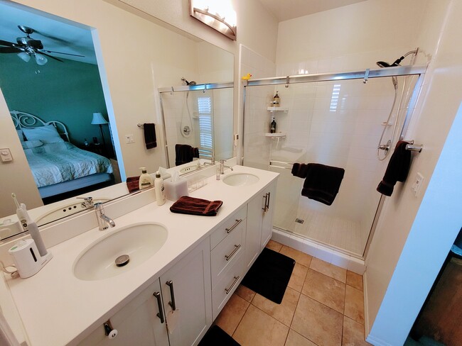 Primary bathroom with dual vanities and walk-in shower - 5552 Coral Dr