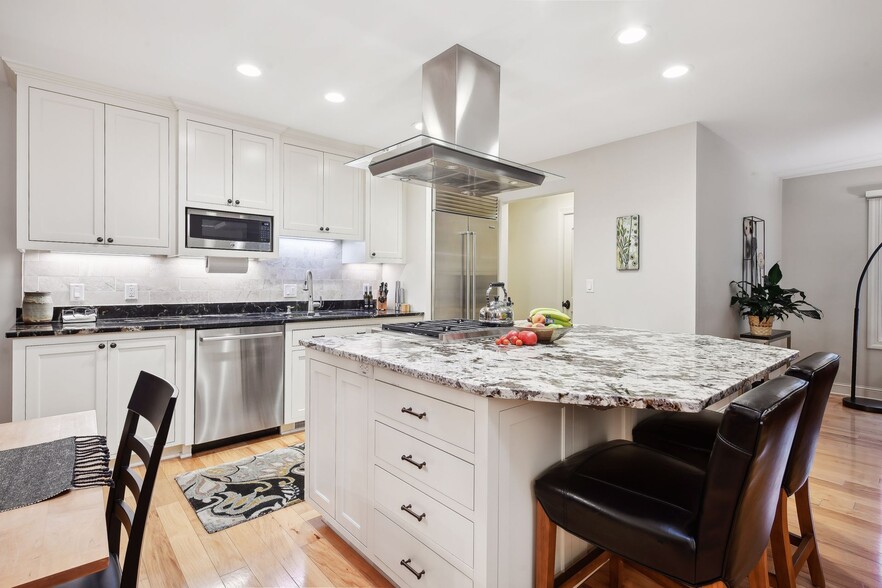 Bright and open, the kitchen features high-end SS appliances, gas range, and granite tops. - 245 Inland Ln N