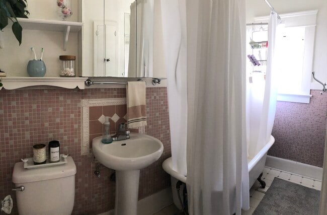 Quaint bathroom with original clawfoot tub and shower enclosure - 616 N Wilson Ave