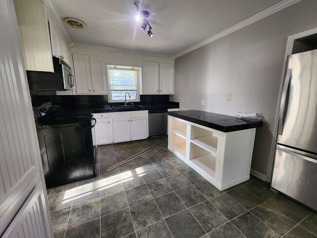 Building Photo - Spacious 4BR/2BA Brick Home with Fireplace, Large Island! NEW LVP Floors throughout!