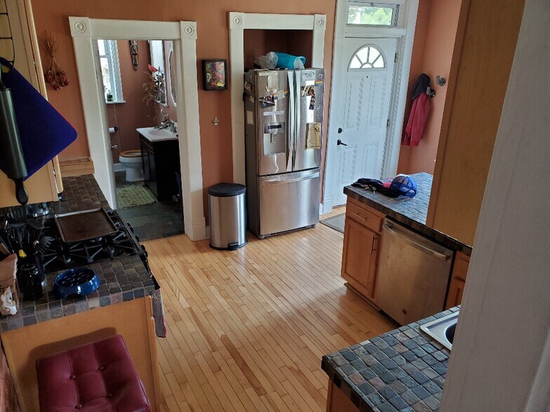 Kitchen. Front (though technically rear) door to the right. Half-bath to the left. - 241 Benton St