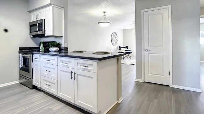Select floor plans feature a breakfast bar, allowing kitchen view overlooks into the living area - perfect for entertaining and sunny wake ups. - Slate Luxury Apartments