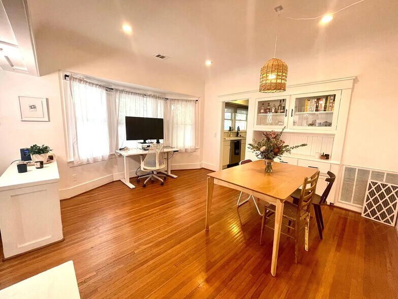 Dining area leading into the kitchen, featuring original built-ins alongside modern updates. - 6000 Carlton Way