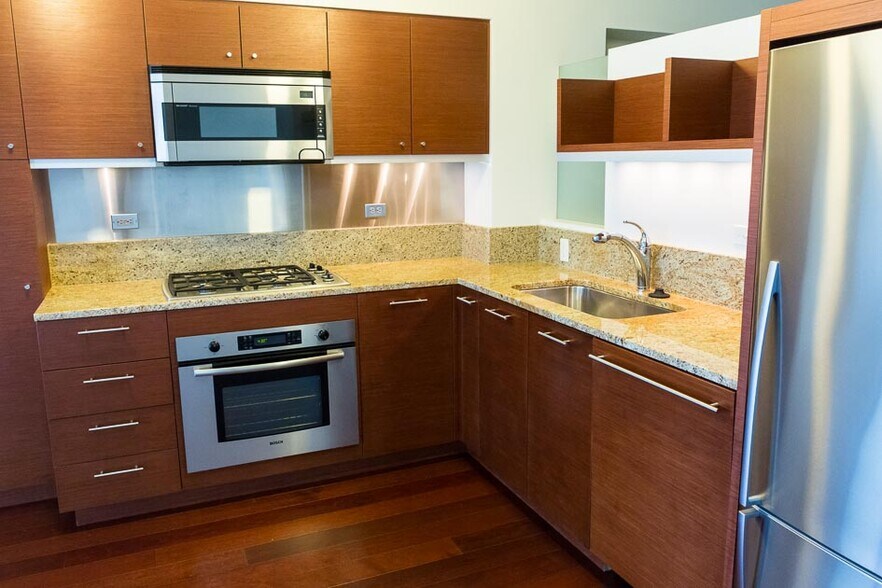 Fully outfitted kitchen with premium cabinets, granite counters, stainless steel appliances, gas range, and under cabinet lighting. - 3601 SW River Pkwy