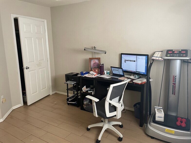 Second bedroom/ office with desk, exercise machine, twin bed, wall mount TV - 2607 Ringold Cir