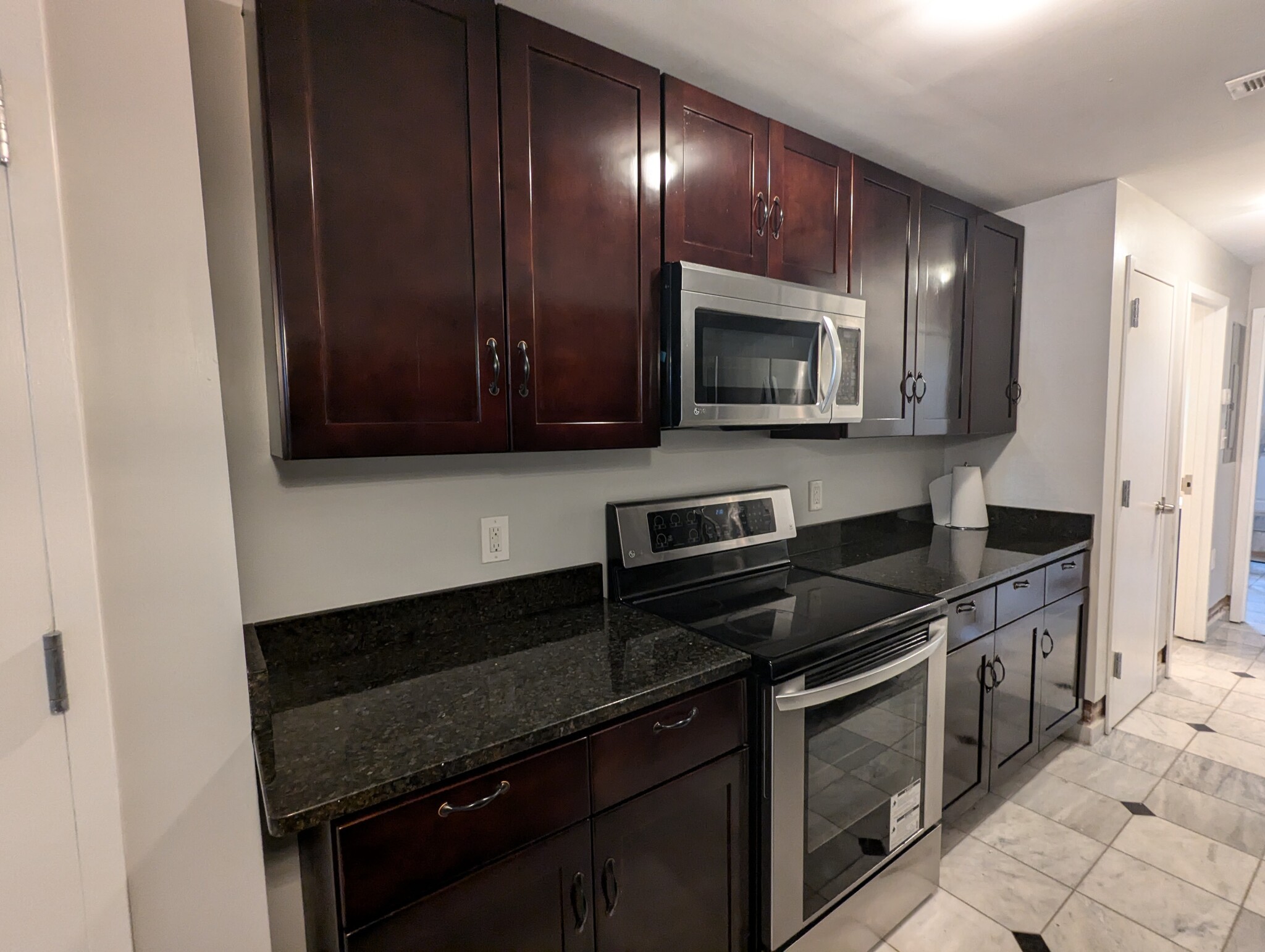 Kitchen, granite counter tops, electric stove and microwave - 2024 N Calvert St