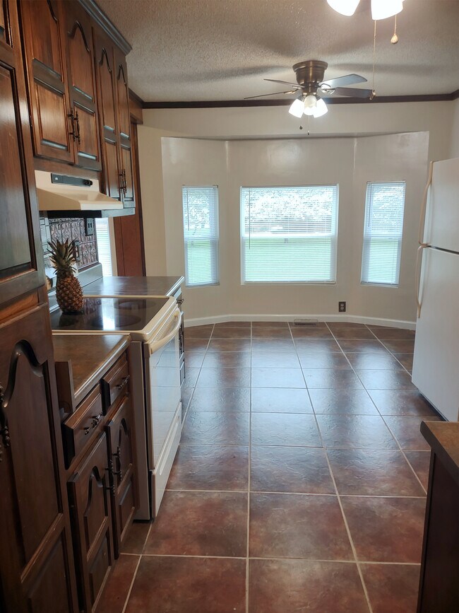 Kitchen has tiled floor, view of back yard and incredible cabinets. - 120 Arrow Lands Trl